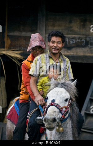 Ein Mönch reitet auf einem Pferd mit Vater und Sohn in BIHI im Bereich buddhistischen NUPRI - um MANASLU Trekking, NEPAL Stockfoto