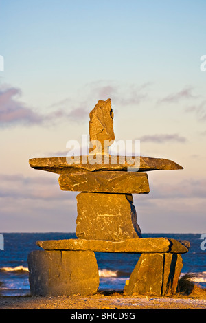 Inukshuk bei Sonnenuntergang in der Stadt Churchill am Ufer des Hudson Bay, Manitoba, Kanada. Stockfoto