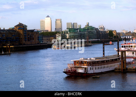 Thames Yacht mit Canary Wharf und finanziellen Zentrum im Hintergrund am Abend Stockfoto