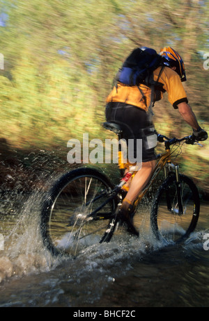 Mann Reiten Fahrrad durch Wasser. Stockfoto