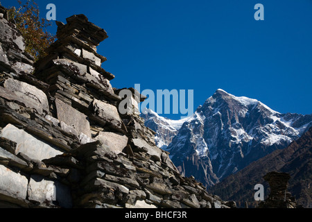 Eine tibetische buddhistische MANI Mauer und Himalaya-Gipfel in NUPRI Umgebung - MANASLU TREK, NEPAL Stockfoto