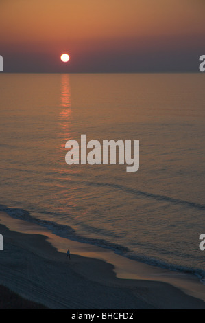 Einsame Person zu Fuß am Strand bei Sonnenaufgang, Myrtle Beach, South Carolina, USA Stockfoto