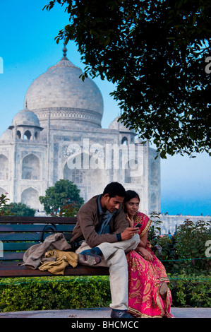 Indische Paare sitzen auf der Bank vor dem Taj Mahal, Indien
