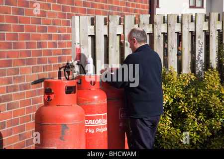 UK, Großbritannien. Arbeiter eine inländischen Calor Gasflasche vor einem Haus ändern Stockfoto