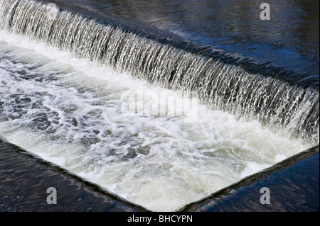 Wasser fließt über eine Overspill Wehr Teil des Grand Union Canal in der Nähe von Harefield Middlesex West London UK Stockfoto