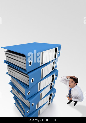 Geschäftsmann gespannt nach einem Blick auf einen Stapel von Dateien Stockfoto