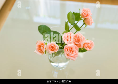 Vase mit Rosen auf Tisch Stockfoto