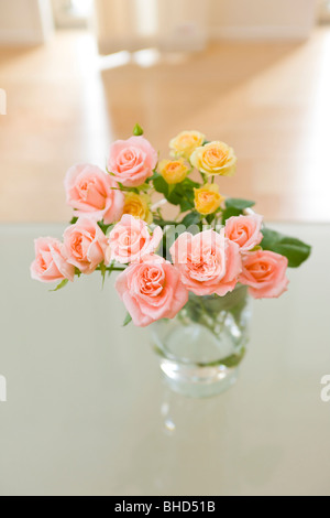 Vase mit Rosen auf Tisch Stockfoto