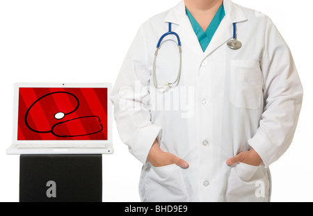 Eine Ärztin, tragen einen Laborkittel mit einem Stethoskop stehen neben einem Laptop-Computer. Stockfoto