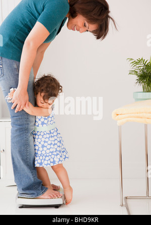 Hispanische Mutter wiegt sich und Tochter Stockfoto