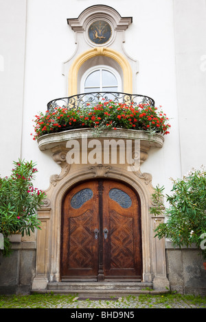 Geschnitzte Holztür und Balkon mit Blumen, Europa Stockfoto