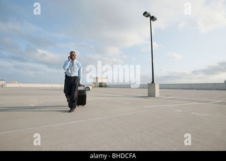 Afrikanische Unternehmer ziehen Gepäck auf Parkplatz Stockfoto