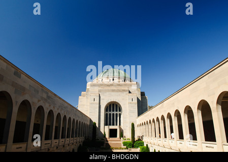 Australian war Memorial Tomb of the Unknown Soldier Canberra Australien | CANBERRA, Australien – die Kupferkuppel der Hall of Memory erhebt sich hinter den bogenförmigen Kreuzgängen des Gedenkhofs des Australian war Memorial, von der Anzac Parade aus gesehen. Die Architekten Emil Sodersten und John Crust kombinierten ihre konkurrierenden Entwürfe aus dem Jahr 1927 zu dem fertigen byzantinisch-ägyptischen Art déco-Komplex, der 1941 am Gedenktag eröffnet wurde. Die Kreuzgänge tragen bronzene „Roll of Honour“-Tafeln, auf denen mehr als 103.000 Australier benannt werden, die seit 1885 in Konflikten ums Leben gekommen sind. Stockfoto