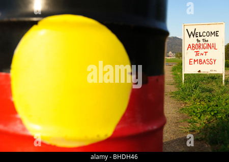Aboriginal Tent Embassy Aboriginal Flag Canberra Australia // CANBERRA, Australien — die australische Aboriginal-Flagge wurde an der Seite einer 44-Liter-Trommel in der Aboriginal Tent Embassy im Old Parliament House in Canberra gemalt. Die Aboriginal Tent Embassy ist eine kontroverse, halbständige Versammlung, die behauptet, die politischen Rechte der australischen Aborigines zu vertreten. Es besteht aus einer großen Gruppe von Aktivisten, Schildern und Zelten, die auf dem Rasen des Old Parliament House in Canberra, der australischen Hauptstadt, wohnen. Stockfoto