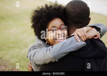 Lächelnd Mischlinge Frau umarmt Freund Stockfoto