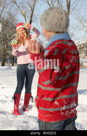 Mutter und Sohn mit Schneeballschlacht In Schneelandschaft Stockfoto