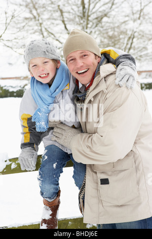 Vater und Sohn stehen draußen In Schneelandschaft Stockfoto