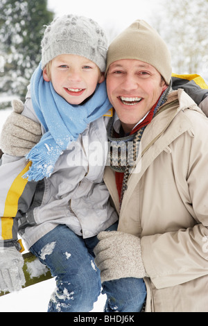 Vater und Sohn stehen draußen In Schneelandschaft Stockfoto