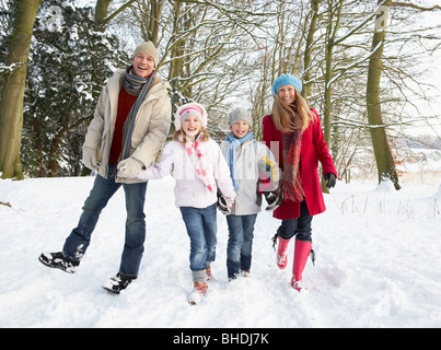 Familie zu Fuß durch den verschneiten Wald Stockfoto