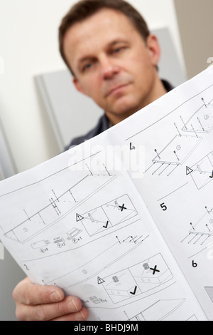 Mann Lesung Montageanleitung für Flachgehäuse Möbel Stockfoto