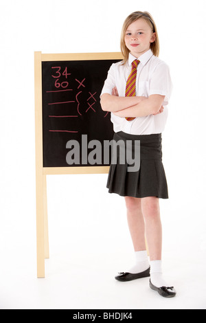 Nachdenklich Studentin in Uniform neben Blackboard Stockfoto