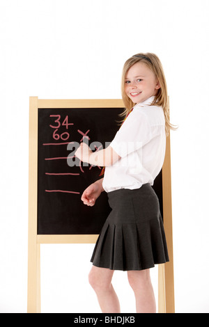 Nachdenklich Studentin in Uniform neben Blackboard Stockfoto