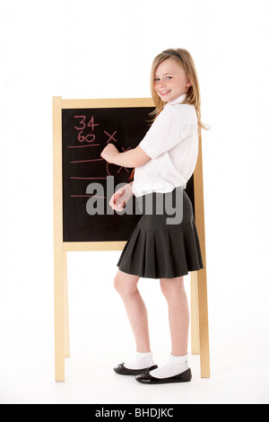 Nachdenklich Studentin in Uniform neben Blackboard Stockfoto