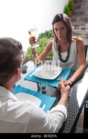 Paar sitzt am Tisch trinken Weißwein Stockfoto