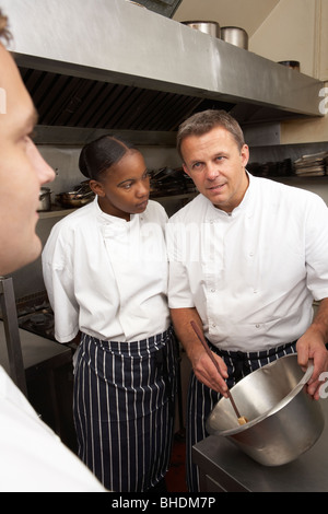 Koch, die Unterweisung von Auszubildenden In Küche Stockfoto