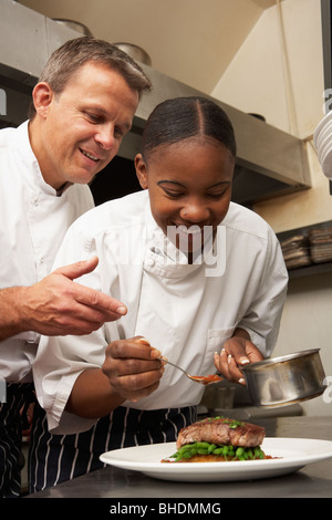 Koch anweist Trainee In Restaurantküche Stockfoto