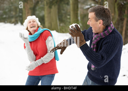 Älteres Paar mit Schneeballschlacht im verschneiten Wald Stockfoto