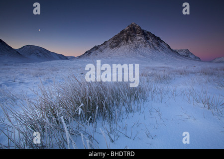 Stob Dearg in der Dämmerung, in Schnee bedeckt, mit Mond oben, Highlands, Schottland Stockfoto