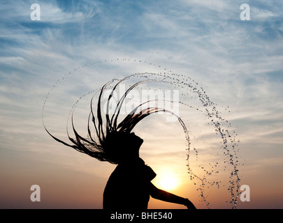 Indische Mädchen werfen ihr nasses Haar zurück verursacht Wasser Spray Silhouette. Indien Stockfoto