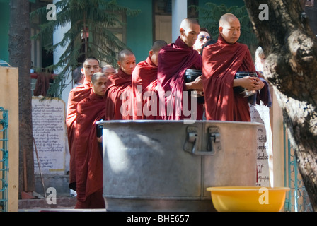 Buddhistische Mönche tragen Reis Schalen, MahaGandhayon Kyaung Kloster Amarapura, Burma, Myanmar Stockfoto