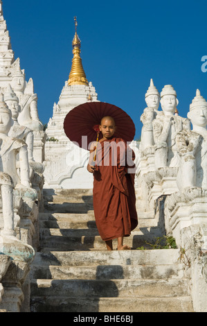 Settawya-Pagode, Young buddhistischer Mönch mit einem roten Regenschirm, Mingun, Burma, Myanmar Stockfoto