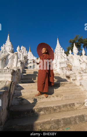 Settawya-Pagode, Young buddhistischer Mönch mit einem roten Regenschirm, Mingun, Burma, Myanmar Stockfoto