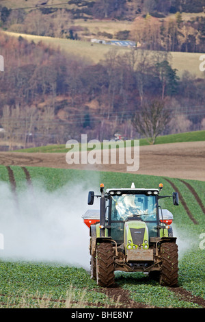 Traktor Spritzen Dünger am Feld im wind Stockfoto