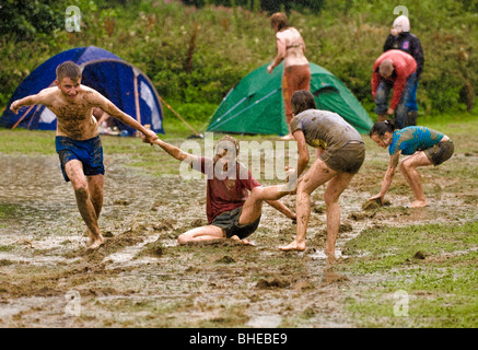 Jugendliche, die nach sintflutartigen Regenfällen auf einem überfluteten Campingplatz im Lake District im Schlamm spielen Stockfoto