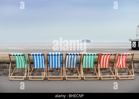 Liegestühle durch den Deich mit steilen Holm Insel am Horizont bei Regensburg Somerset UK Stockfoto