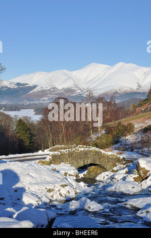 Ashness Brücke Cumbria im Winter mit Skiddaw in der Ferne mit Schnee bedeckt Stockfoto