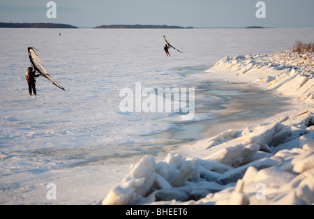 Menschen Skifahren auf Eisschollen im Winter mit einem Kitewing, Finnland Stockfoto