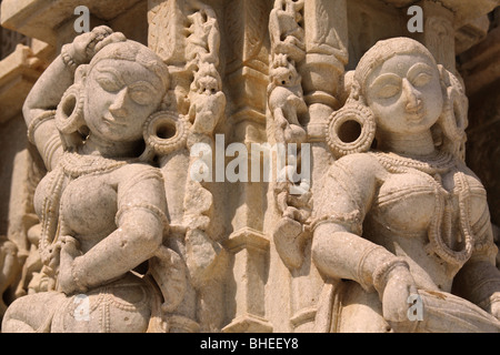 Weiße Stein Jain oder Hindu tanzenden Mädchen mit große Creolen, Ketten und anderen Schmuck - Skulpturen auf einem Jain-Tempel. Stockfoto