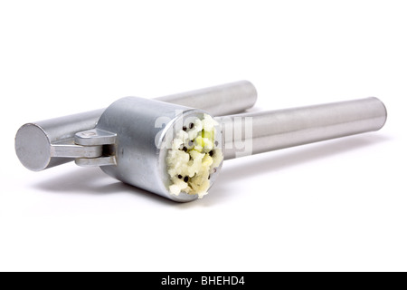 Zerdrückten Knoblauch Nässen aus glänzendem Silber Knoblauchpresse auf weißen Hintergrund isoliert. Stockfoto