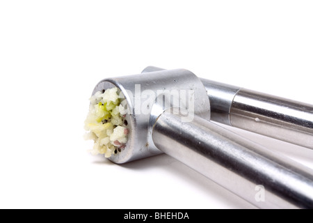 Zerdrückten Knoblauch Nässen aus glänzendem Silber Knoblauchpresse auf weißen Hintergrund isoliert. Stockfoto