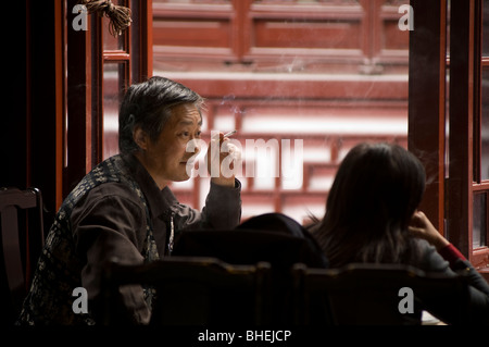 Mann Rauchen in einem Restaurant in der Yu-Garten-Basar, Shanghai, China, Asien Stockfoto