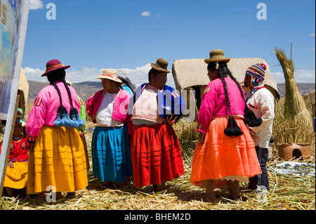 Frauen und junge aus der Insel von Verköstigung, Inseln der Uros, Titicacasee, Peru bunte Tracht Stockfoto