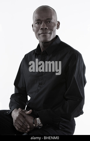 Studio, Porträt eines lächelnden vierzig Handsome afroamerikanischen Mannes mit einem schwarzen Hemd erschossen Stockfoto