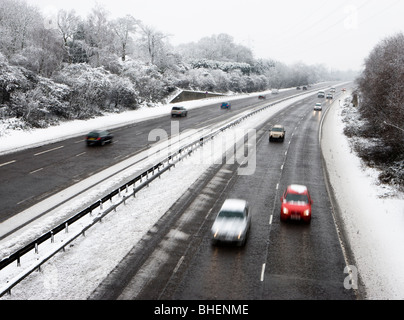 Verkehr auf der Schnellstraße im Schnee. Zwei Fahrspuren durch Winterstreudienste gelöscht. Surrey, UK Stockfoto