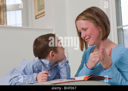 Frau Unterzeichnung das Wort "Ziehen" in amerikanischer Gebärdensprache während des Unterrichts ihren Sohn Stockfoto