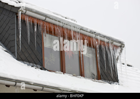 sehr lange Eiszapfen auf einer Dachgaube im winter 2009/2010 in Deutschland Stockfoto